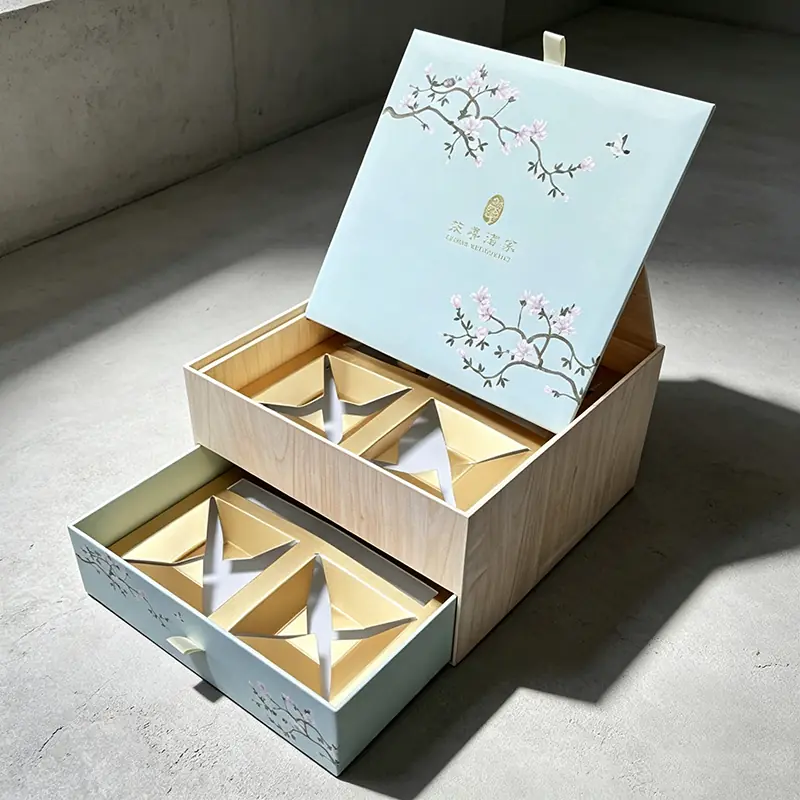 An elegant double-layer wooden-textured gift box with a soft mint green lid adorned with floral illustrations, featuring a sliding base drawer and laser-cut geometric golden inserts for premium tiered corporate corporate gifts.