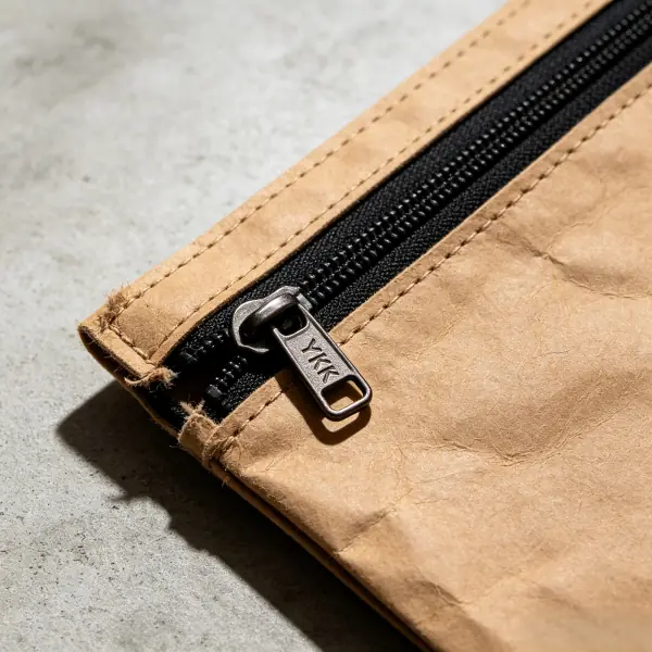 Close up of smooth YKK zipper pull on natural tan washable kraft paper pouch